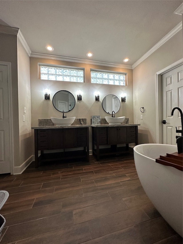 bathroom featuring a wealth of natural light, vanity, a bathtub, and wood-type flooring