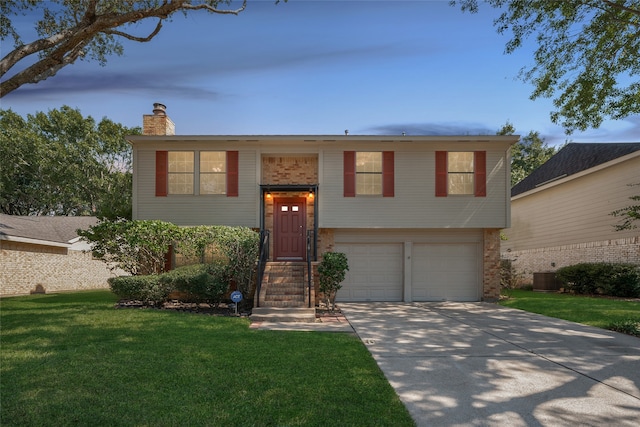 split foyer home with a front yard, central AC, and a garage