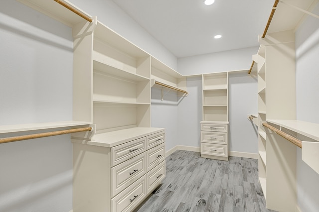 walk in closet with light hardwood / wood-style flooring