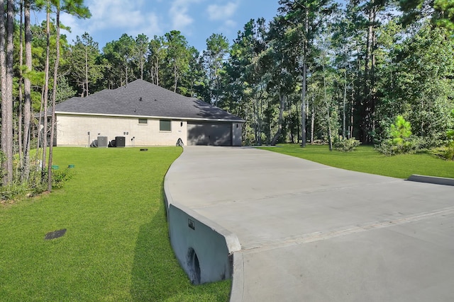 exterior space featuring a garage, central air condition unit, and a lawn