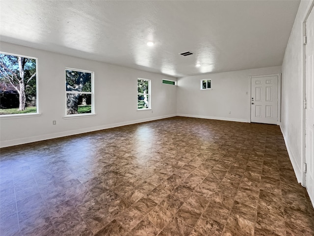 unfurnished room with a textured ceiling