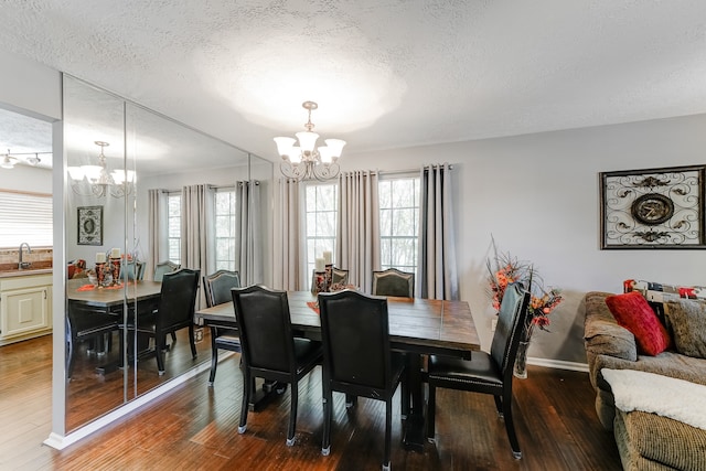 dining room with hardwood / wood-style flooring, a notable chandelier, and a textured ceiling