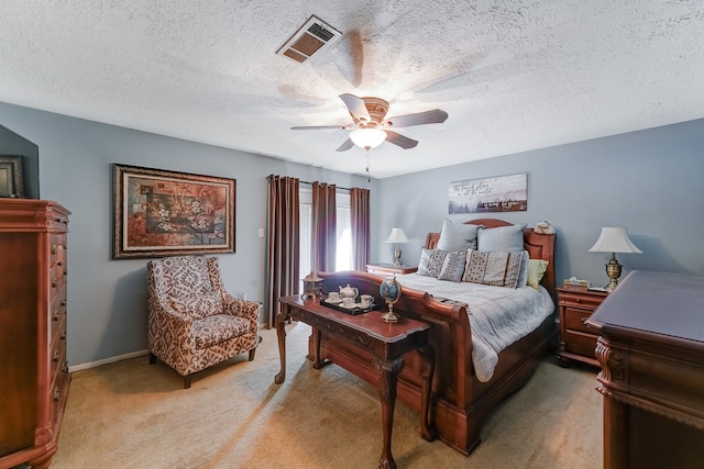 bedroom featuring light carpet, a textured ceiling, and ceiling fan