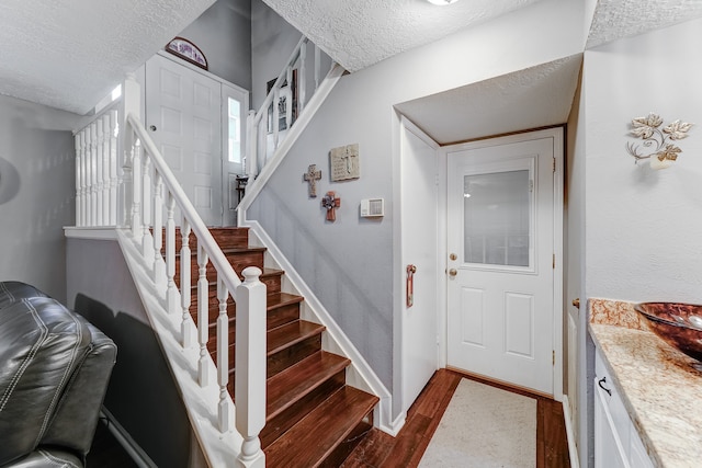 foyer featuring dark wood-type flooring and a textured ceiling