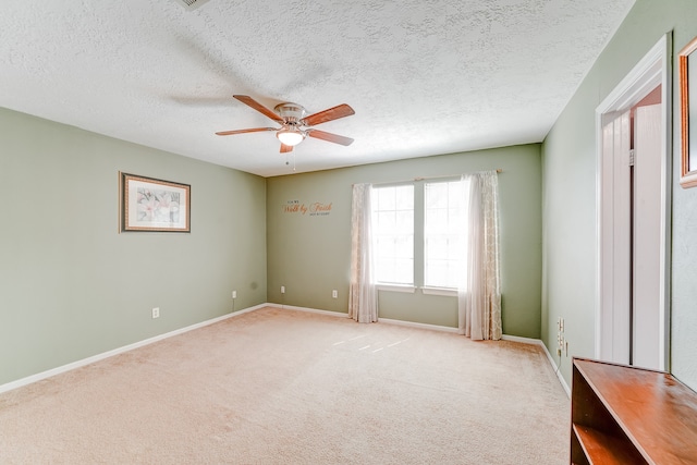 spare room with light carpet, a textured ceiling, and ceiling fan