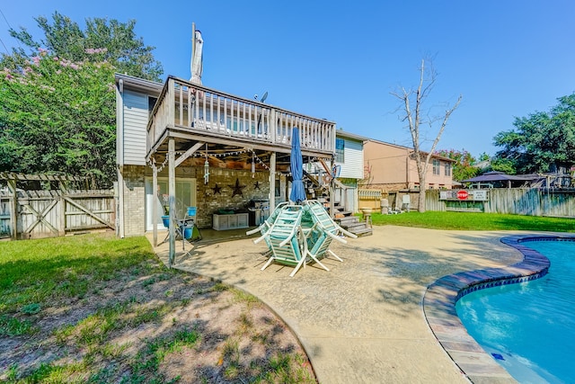 rear view of house with a yard, a swimming pool side deck, and a patio