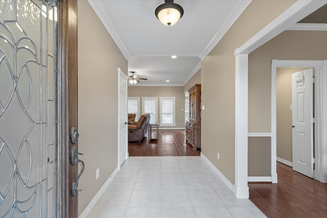 foyer entrance featuring crown molding, light hardwood / wood-style floors, and ceiling fan