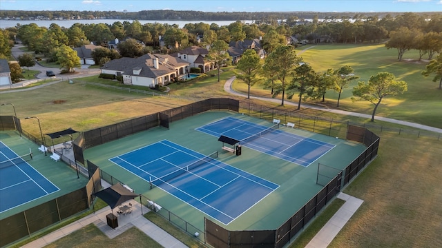 view of tennis court with a water view