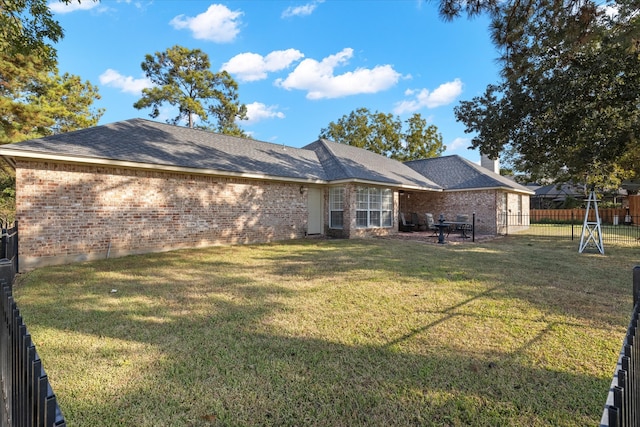 rear view of house with a patio and a lawn