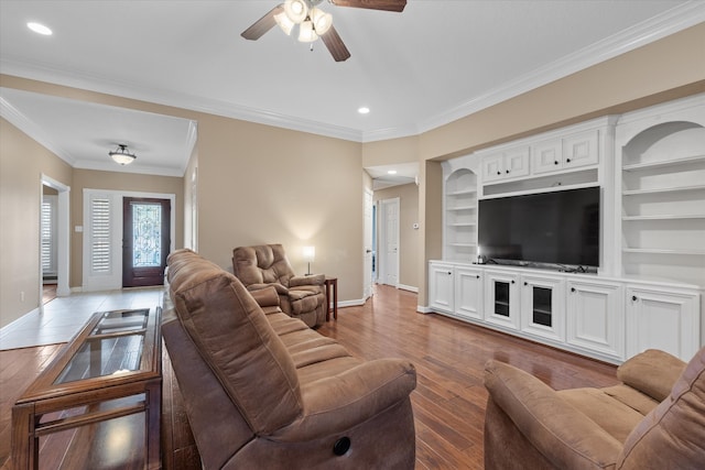 living room with light hardwood / wood-style floors, ornamental molding, built in features, and ceiling fan