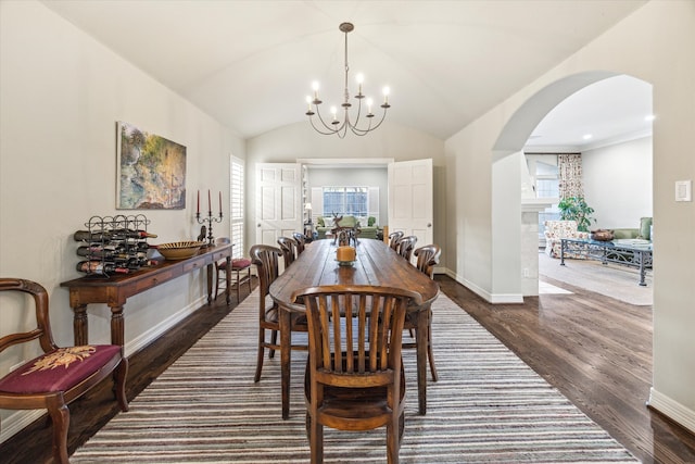 dining room with dark wood-type flooring, a notable chandelier, and lofted ceiling