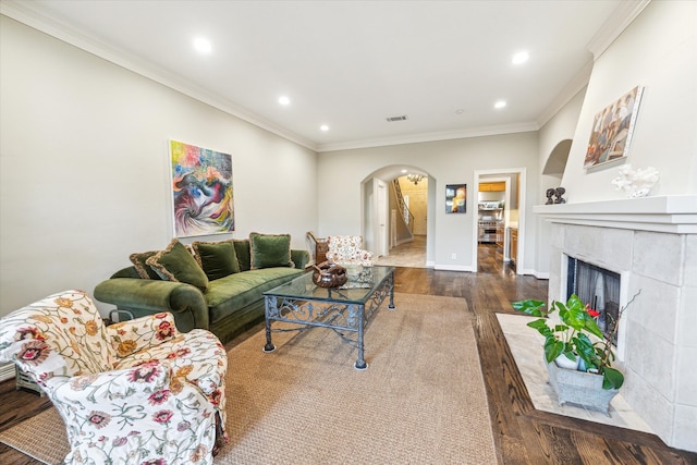 living room featuring ornamental molding, a tile fireplace, and dark hardwood / wood-style flooring