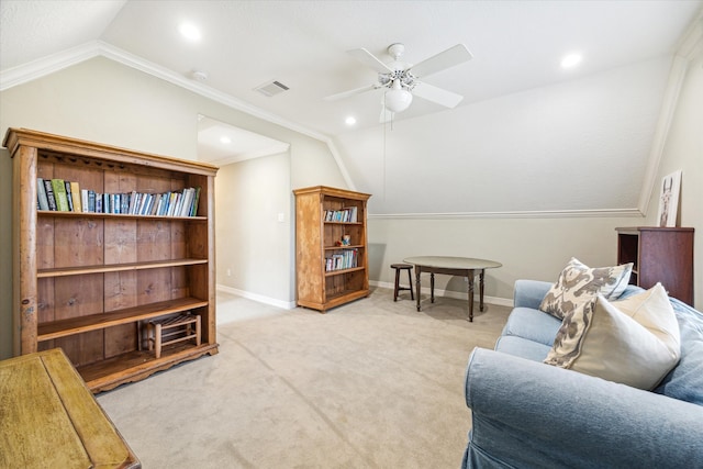 interior space featuring ornamental molding, light colored carpet, vaulted ceiling, and ceiling fan