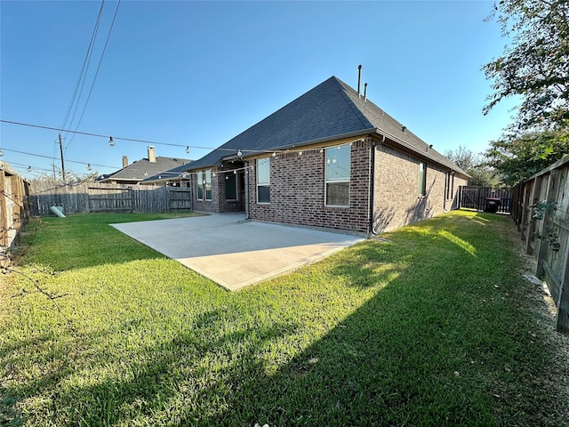 back of house with a yard and a patio