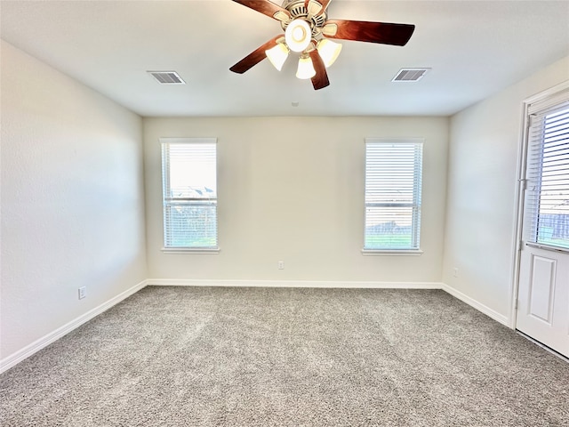 carpeted empty room featuring ceiling fan and plenty of natural light