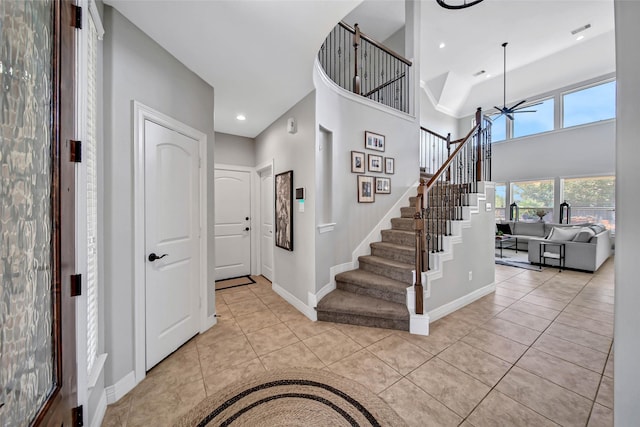 foyer with light tile patterned floors and ceiling fan