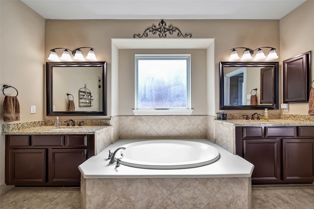 bathroom with tile patterned floors, vanity, and tiled bath