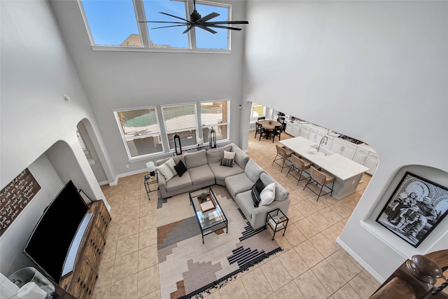 tiled living room with a towering ceiling and ceiling fan