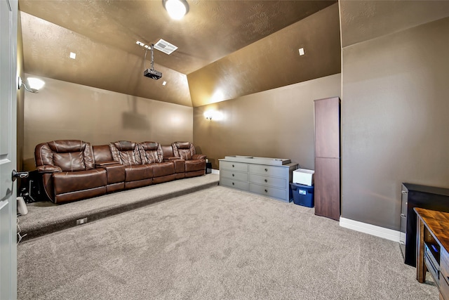 home theater room with carpet and vaulted ceiling