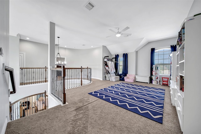 playroom with ceiling fan with notable chandelier, carpet floors, and vaulted ceiling