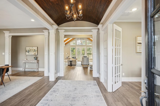 38134 Cascade Ct, Magnolia, TX 77354 - foyer entrance featuring ornate columns, lofted ceiling, wood finished floors, a chandelier, and ornamental molding