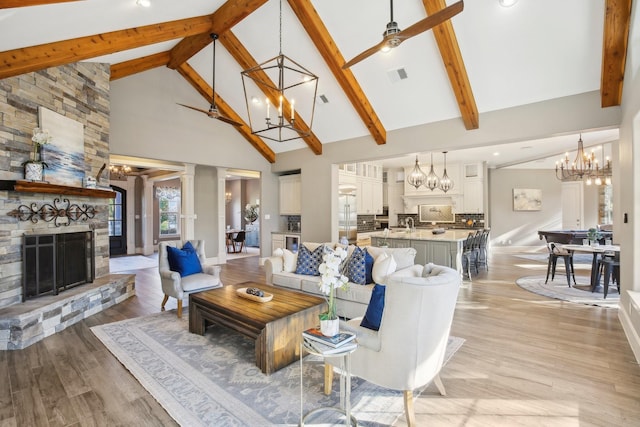 38134 Cascade Ct, Magnolia, TX 77354 - living room featuring a chandelier, high vaulted ceiling, a fireplace, light wood-style floors, and beamed ceiling