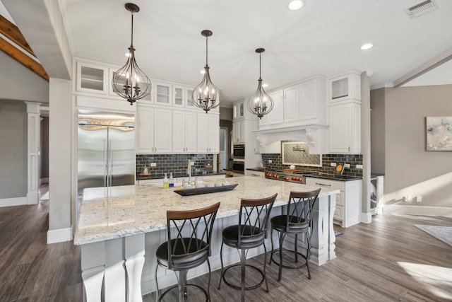 38134 Cascade Ct, Magnolia, TX 77354 - kitchen featuring dark wood-style flooring, tasteful backsplash, white cabinets, stainless steel appliances, and recessed lighting