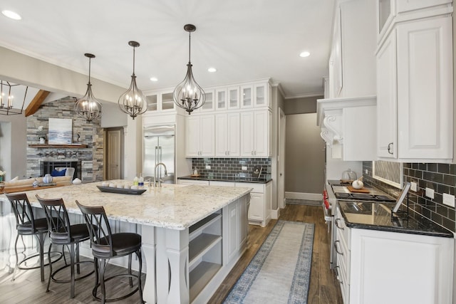 38134 Cascade Ct, Magnolia, TX 77354 - kitchen featuring premium appliances, tasteful backsplash, white cabinets, recessed lighting, and crown molding
