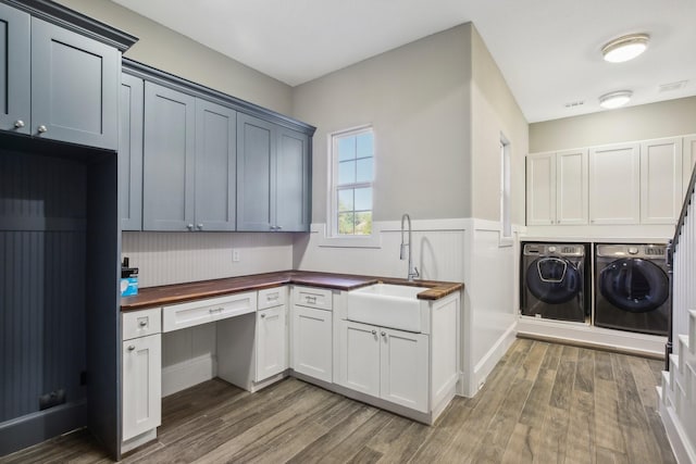 38134 Cascade Ct, Magnolia, TX 77354 - laundry room with washer and dryer, cabinet space, wood finished floors, and a wainscoted wall