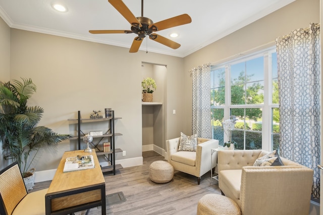 living area with light hardwood / wood-style floors, ceiling fan, and crown molding