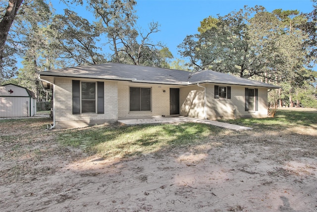 back of house featuring a storage unit