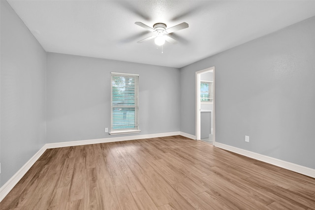 empty room with light hardwood / wood-style floors, plenty of natural light, and ceiling fan