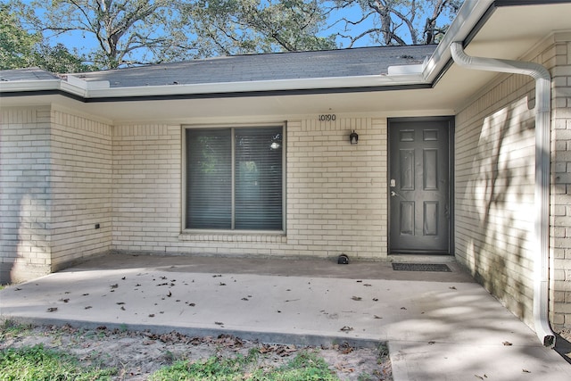 view of exterior entry with a patio area