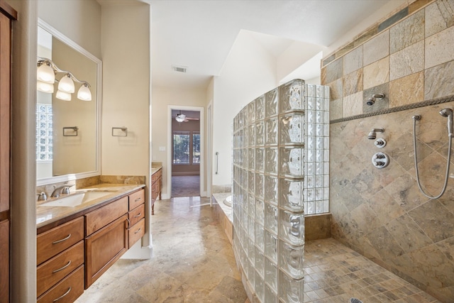 bathroom with vanity, ceiling fan, a wealth of natural light, and tiled shower