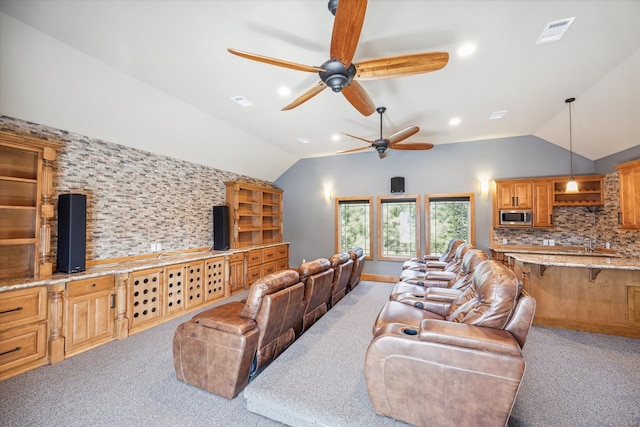 carpeted living room featuring lofted ceiling, sink, and ceiling fan