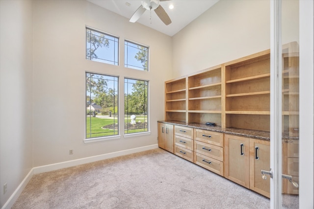 interior space featuring light carpet, high vaulted ceiling, and ceiling fan