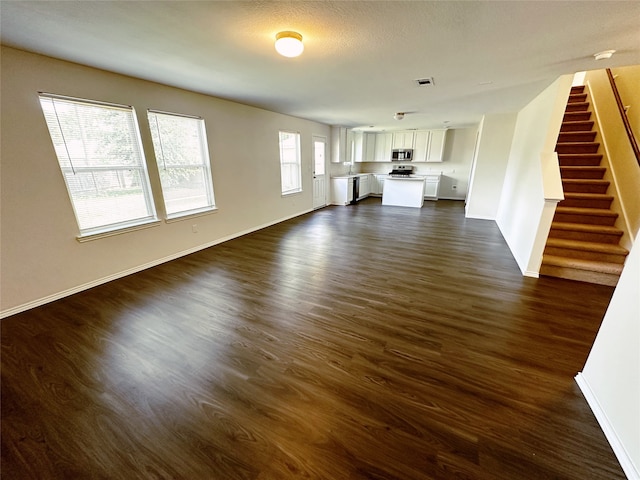 unfurnished living room with dark hardwood / wood-style floors