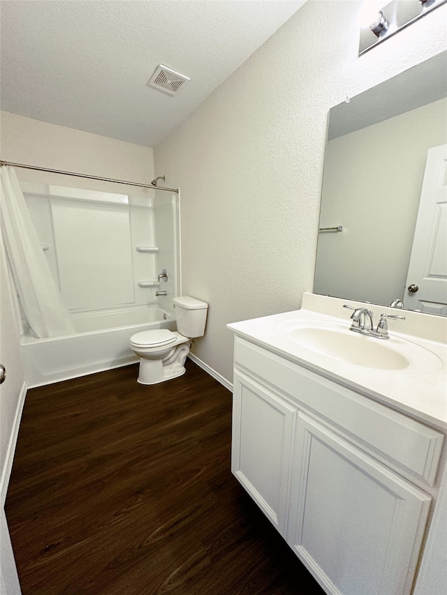 full bathroom with a textured ceiling, shower / bathtub combination with curtain, wood-type flooring, toilet, and vanity