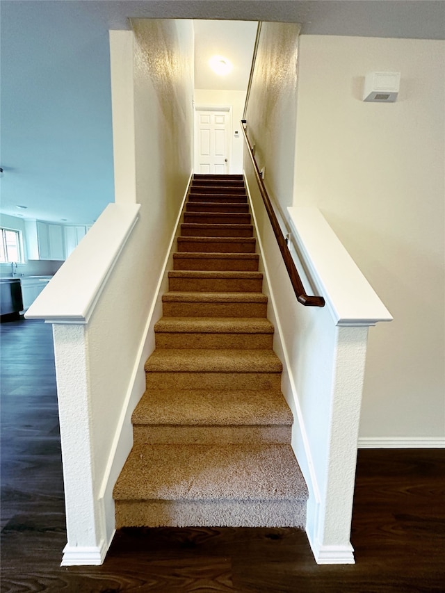 staircase with hardwood / wood-style floors