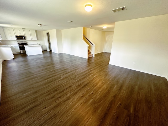 unfurnished living room with dark wood-type flooring