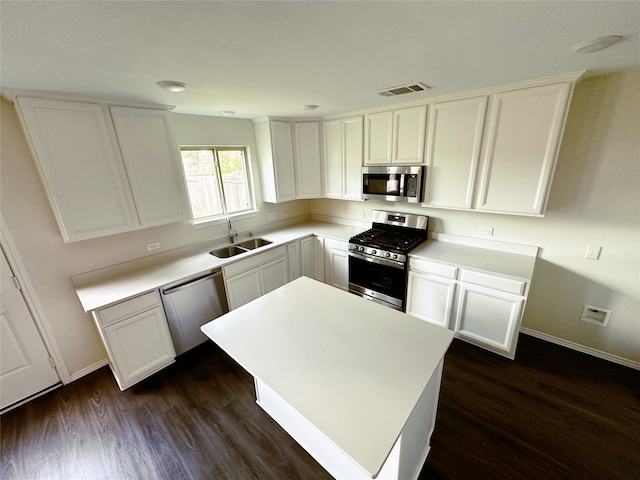 kitchen with appliances with stainless steel finishes, white cabinetry, and sink