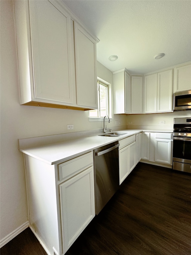 kitchen featuring sink, white cabinetry, stainless steel appliances, and dark hardwood / wood-style flooring