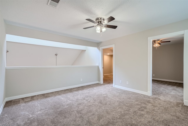 interior space with lofted ceiling, a textured ceiling, and ceiling fan