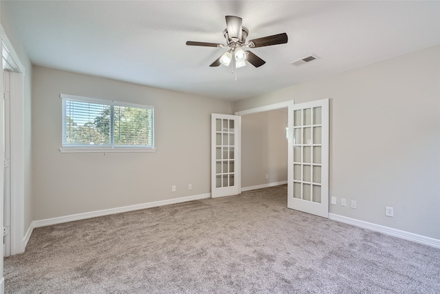 carpeted spare room with french doors and ceiling fan