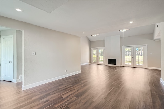 unfurnished living room featuring french doors, dark hardwood / wood-style floors, and a large fireplace