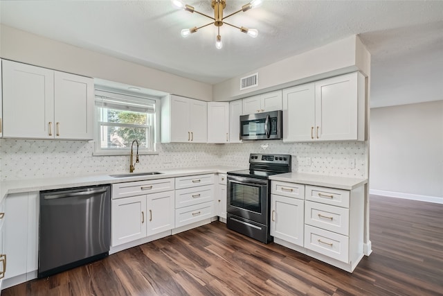 kitchen with appliances with stainless steel finishes, white cabinets, sink, and dark hardwood / wood-style floors