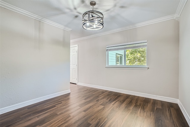 empty room with crown molding, dark hardwood / wood-style floors, and a chandelier