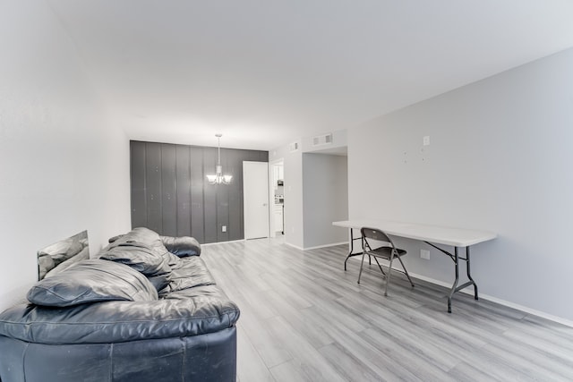 living room featuring an inviting chandelier and light wood-type flooring