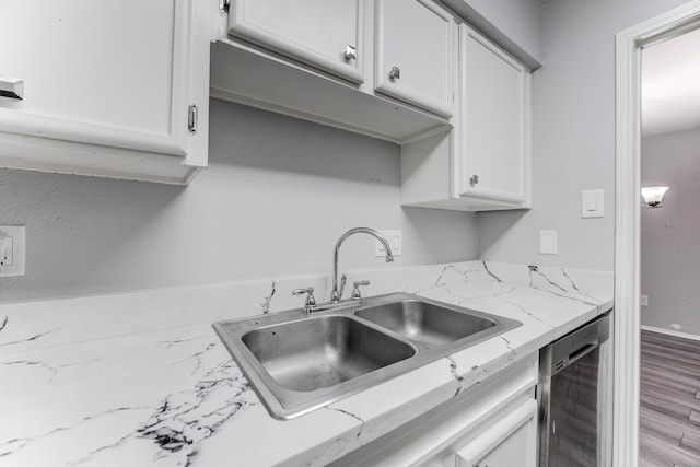 kitchen with light stone countertops, sink, dishwasher, light hardwood / wood-style floors, and white cabinets