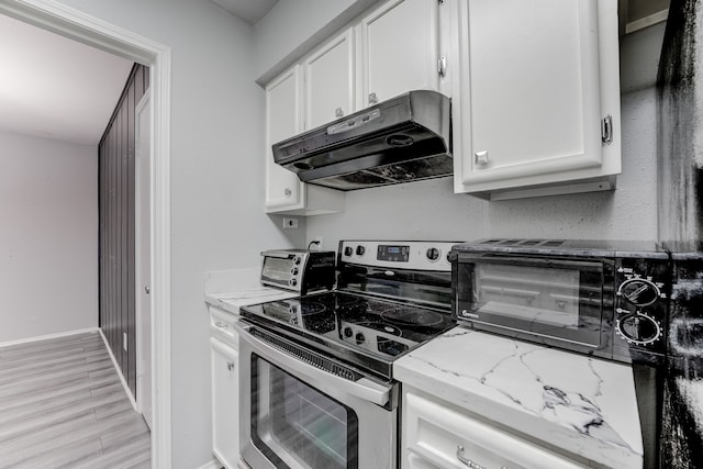 kitchen featuring white cabinetry, electric stove, light stone countertops, and light hardwood / wood-style floors